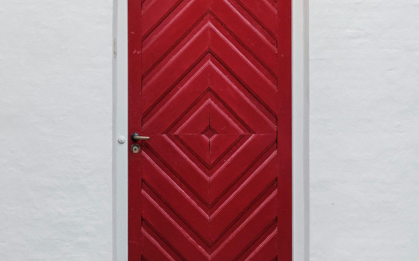 closed red wooden door by Lasse Møller courtesy of Unsplash.