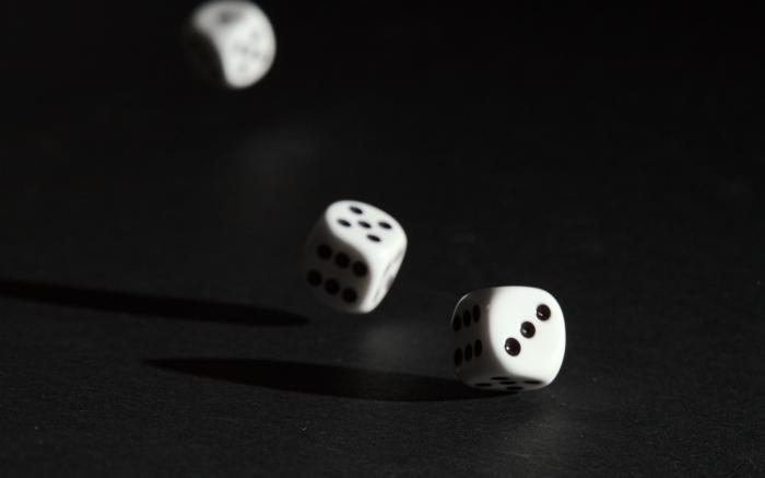 3 white dice on black surface by Alois Komenda courtesy of Unsplash.