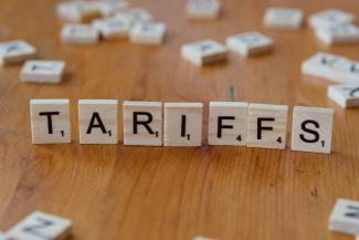 A wooden block spelling tarifs on a table by Markus Winkler courtesy of Unsplash.