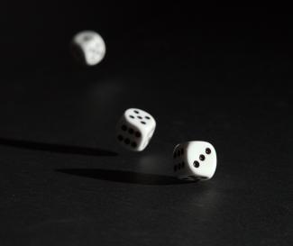 3 white dice on black surface by Alois Komenda courtesy of Unsplash.