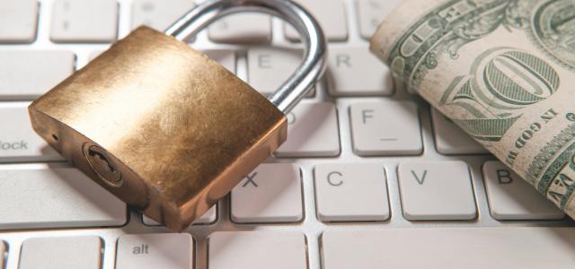 A padlock and dollar bills rest on a computer keyboard. by Sasun Bughdaryan courtesy of Unsplash.