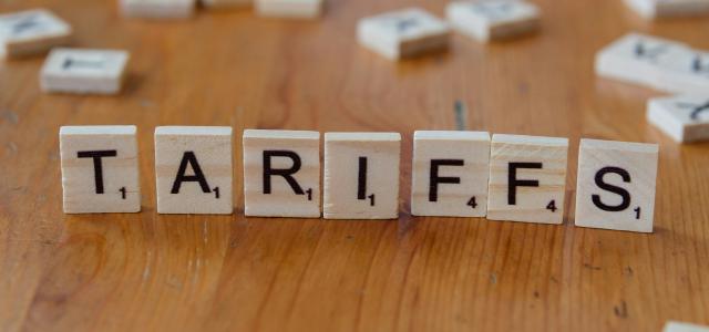 A wooden block spelling tarifs on a table by Markus Winkler courtesy of Unsplash.